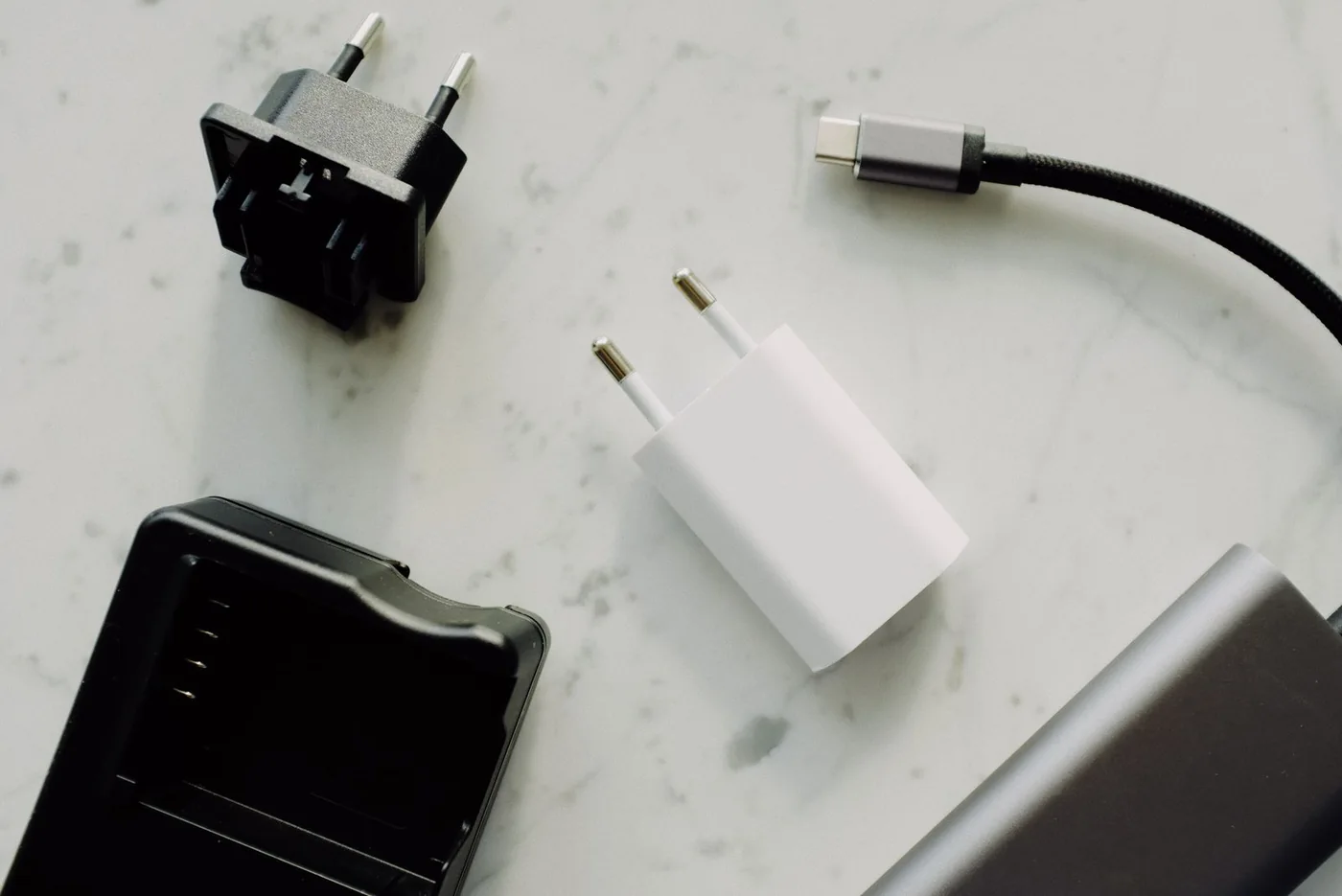 USB-C cable and power adapters resting on a light marble surface