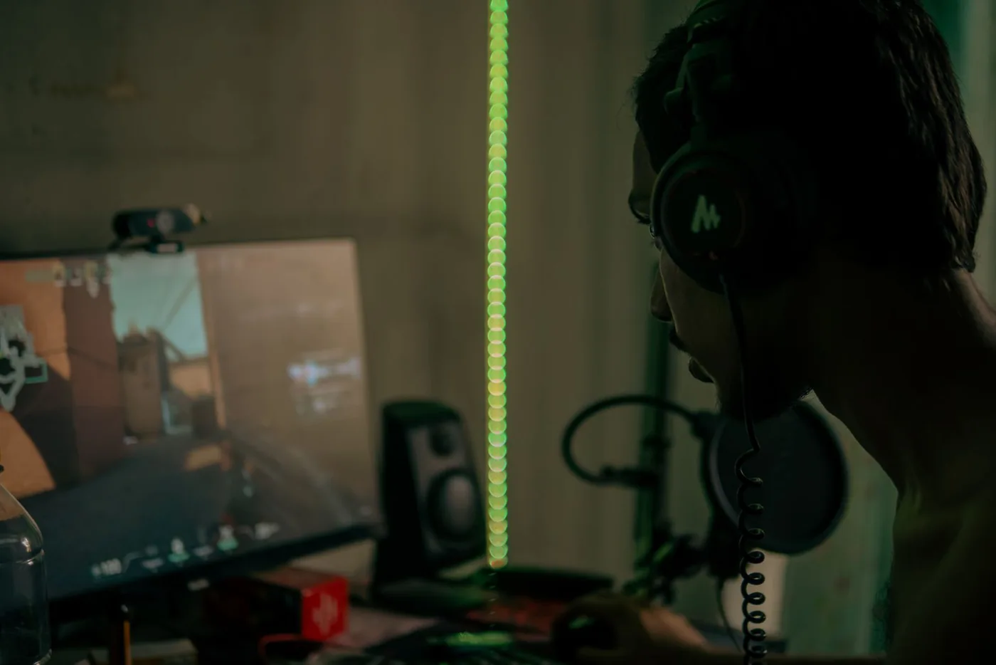 Person wearing a headset while playing a game at a computer desk
