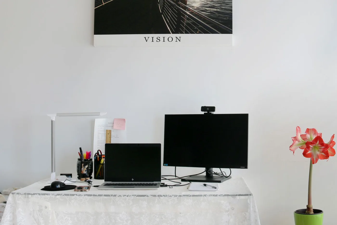 Laptop and monitor with a webcam on a white home office desk